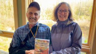 Dave Warners and Gail Heffner holding their new book, "Reconciliation in a Michigan Watershed."
