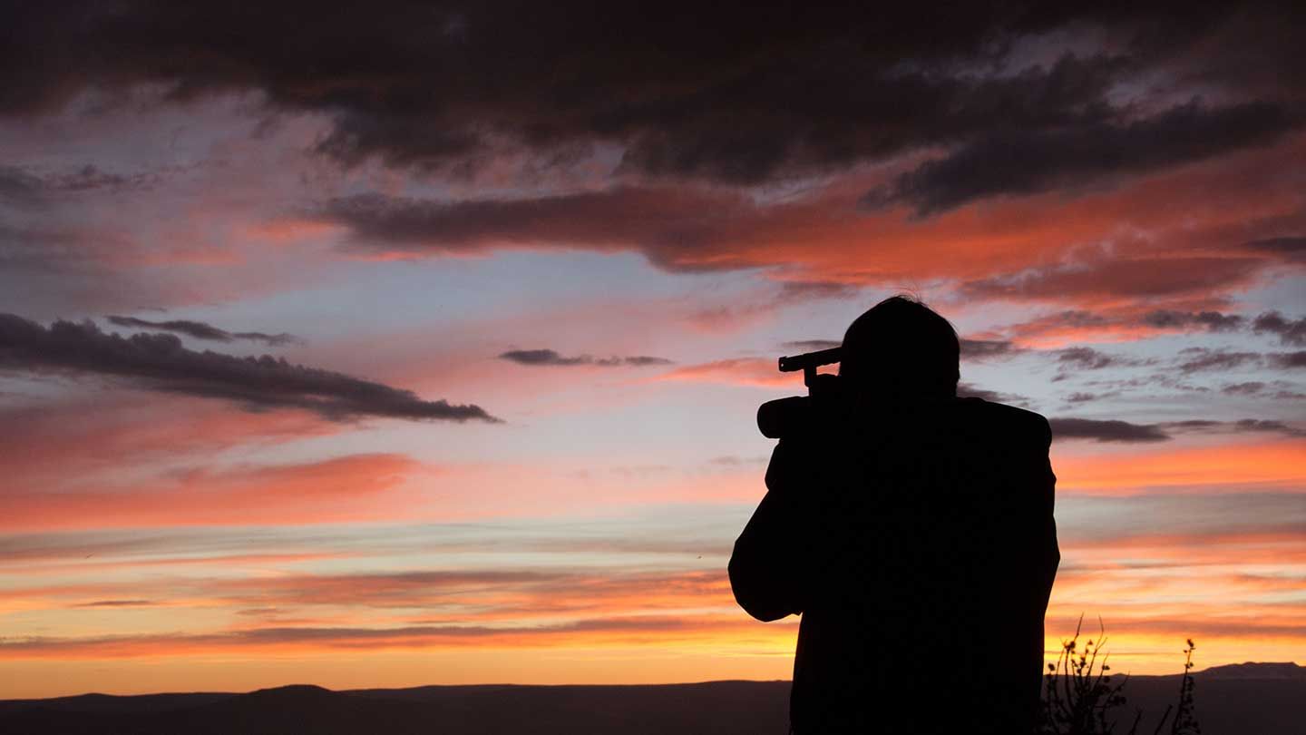 Sam Smartt shooting in Wyoming against a dramatic sunset