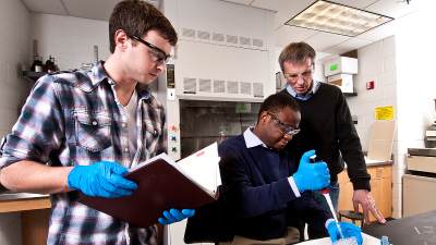 Prof. Larry Louters with students in a chemistry lab.