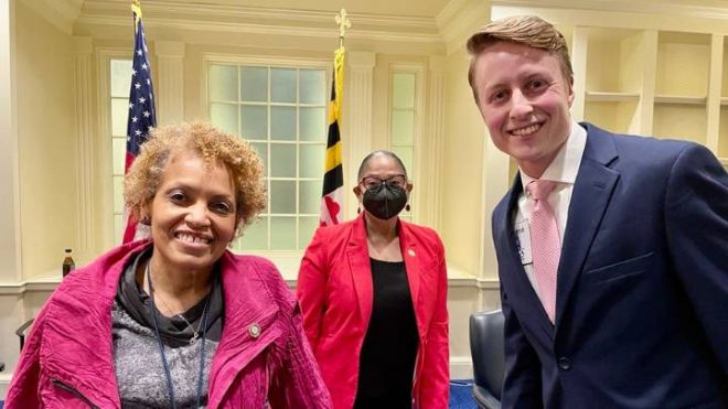 An African American woman stands next to Noah Praamsma inside the Maryland State House.
