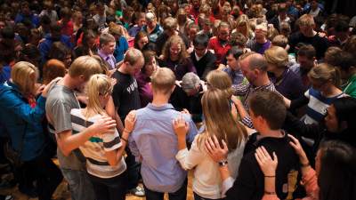 Members of the Calvin College community lay hands on Michael Le Roy in prayer.
