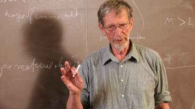 Alvin Plantinga in front of a chalkboard.