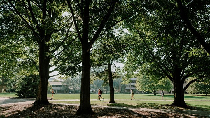 Students walking across Calvin's tree-filled campus.
