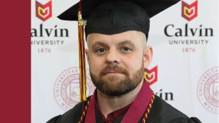 A man in cap and gown, donning honors cords poses in front of Calvin University formal backdrop.