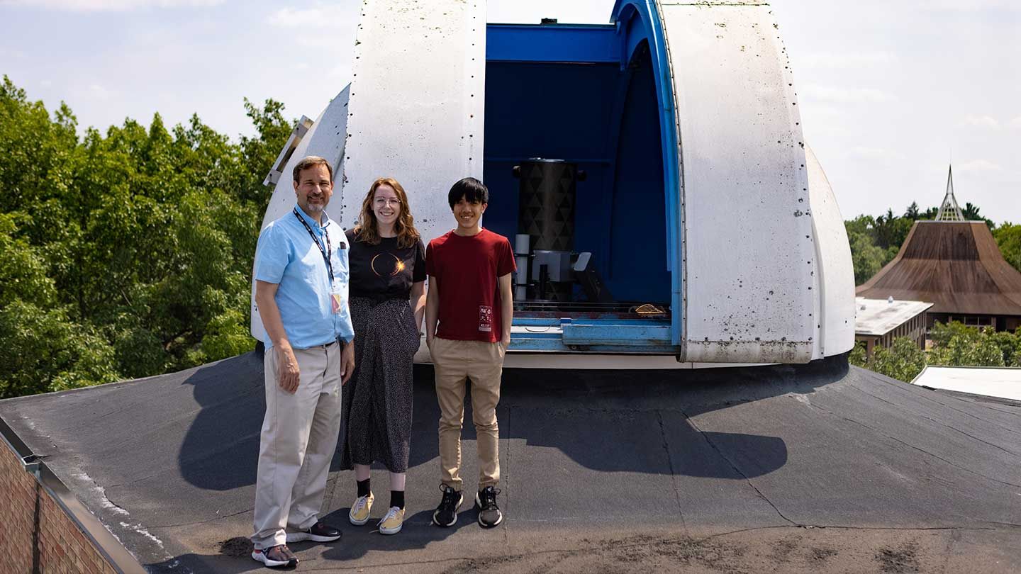 Professor Molnar standing with students next to the Calvin telescope