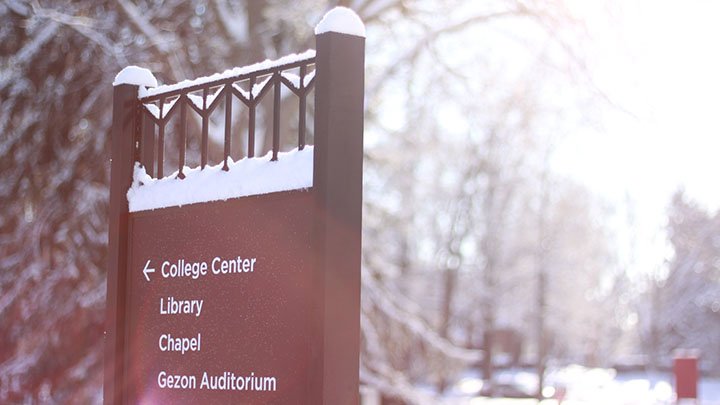 A Calvin College sign with a snowy backdrop.