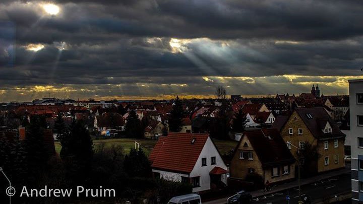 Sunlight shines through thick clouds onto a neighborhood in Germany