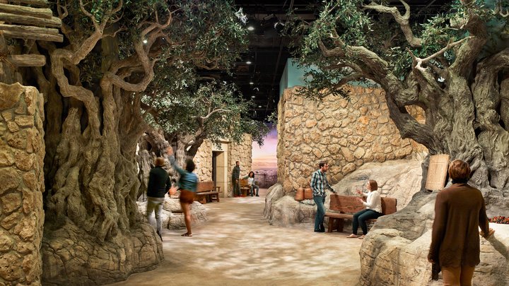 People explore a museum exhibit reconstruction of an ancient town.