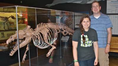 Ryan Bebej with his summer research assistant, Melissa Braun beside a whale fossil display case.