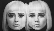 Two members of Lucius stare into the camera. Pic is edited to look like the faces are coming togethe