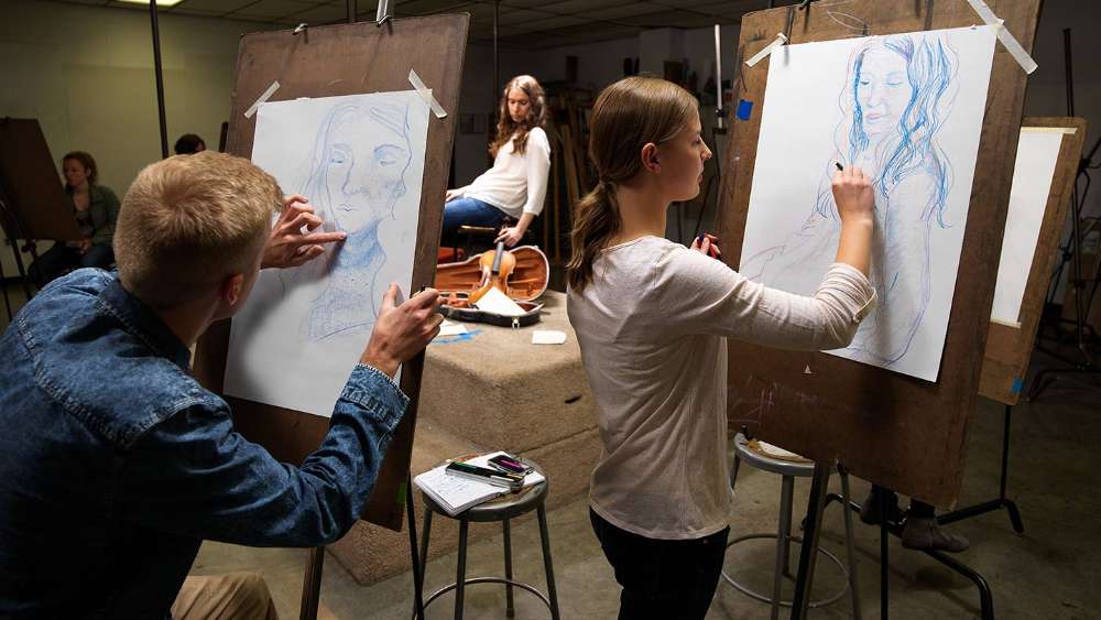 Students sketching a model in a studio