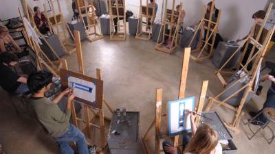 Students painting on easels in an art studio at Calvin.