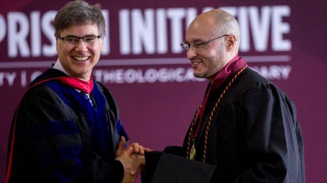 Calvin University English professor David Urban congratulates 2023 grad Wilson Rivera Beys who graduated with distinction.