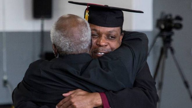 2023 grad Marcus Johnson hugs his family during the 2023 Commencement ceremony at Handlon Correctional Facility.