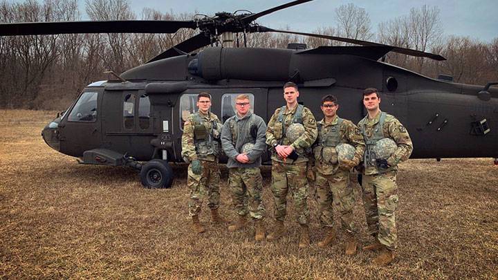Calvin ROTC cadets Max, Ian, Joshua, Nicholas, and Andrew alongside a U.S. Army helicopter at Riverview Airport in Georgetown Township, MI.