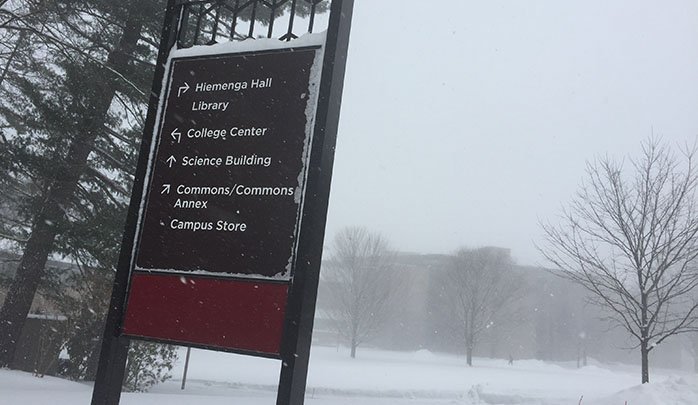 Calvin College sign with a wintery background.