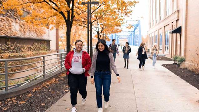 Two Calvin University students walking in downtown Grand Rapids, Michigan, in autumn.