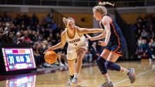 Calvin University women's basketball player dribbling a ball