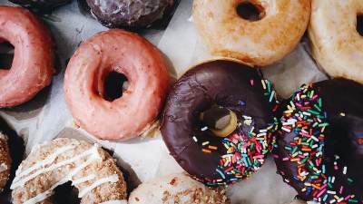 Detailed photo of a variety of donuts, with crumbling glaze and sprinkles
