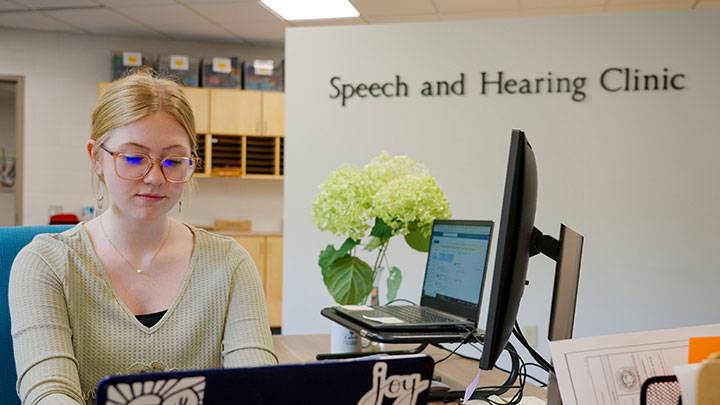A SPAUD student attends the front desks of Calvin's new Speech and Hearing Clinic.