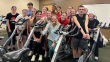 A photo of Calvin student Macy Gerig and a group of students with Spin Bikes in foreground.