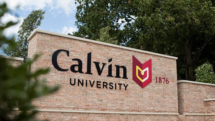 A  monument sign that says Calvin University located at the university's main entrance to campus