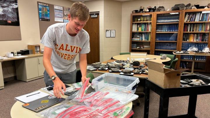 Zach Guikema organizing plastic ziplock bags full of sediment he collected from rooftops.