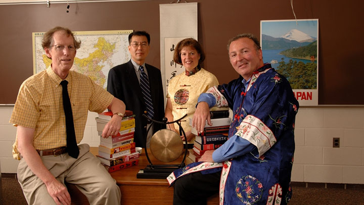 Four Asian Studies faculty members pose together in a classroom.