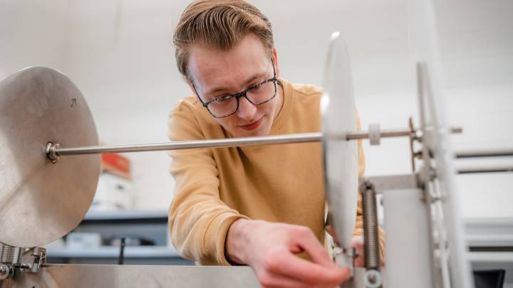 A closeup of a student working intently on his senior design engineering project.