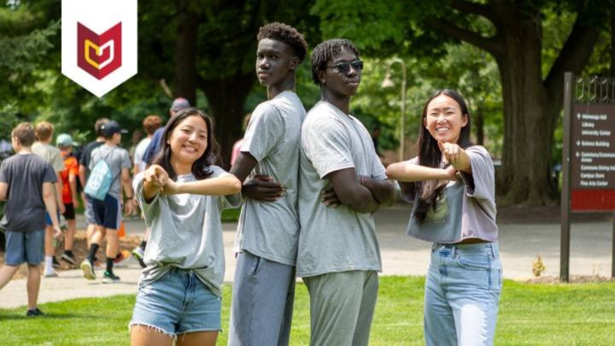 Four students pose on the Commons Lawn at Calvin University.