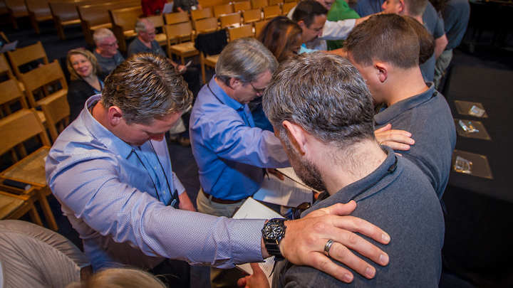 Van Lunen Fellows praying in a circle with arms on each other's shoulders