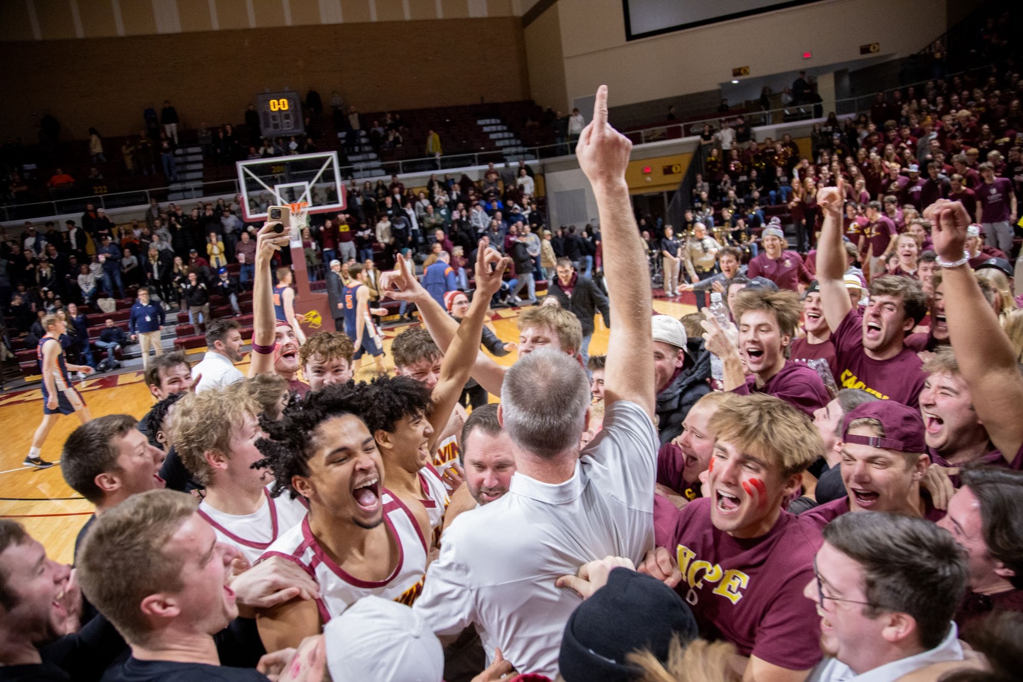 Calvin's men's basketball team celebrating after a win versus Hope College