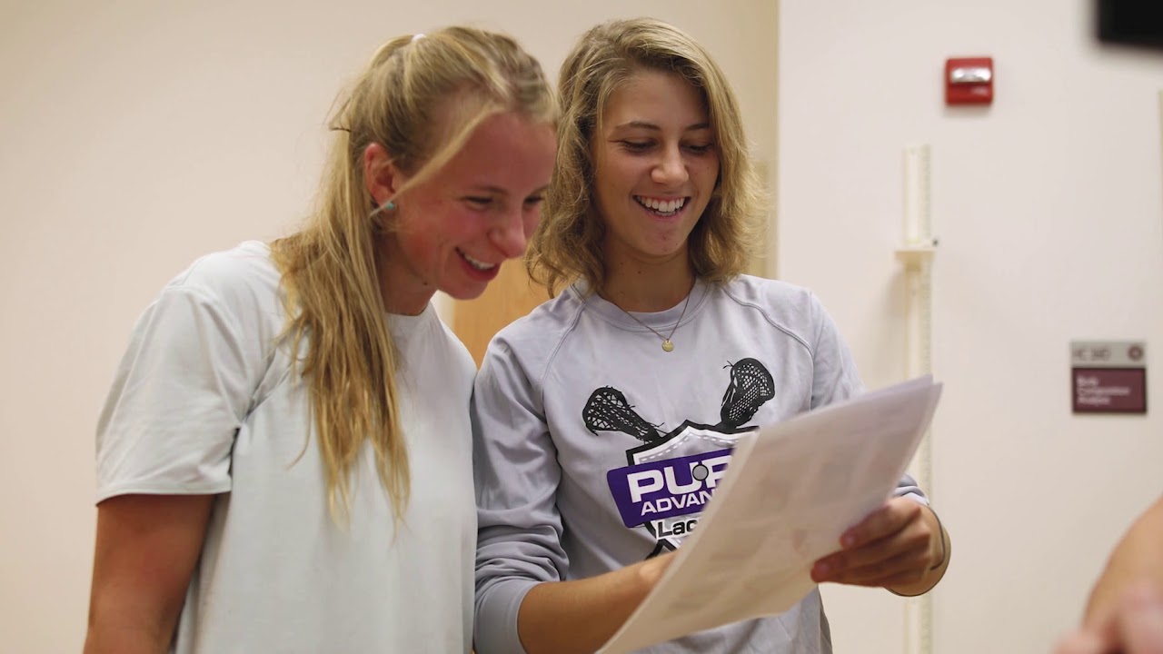 Two female kinesiology students share a look at some documents