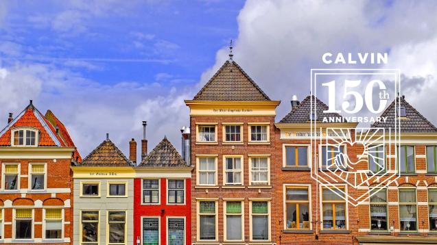 A row of colorful brick houses with many windows and pointed roofs, in Delft, Netherlands.