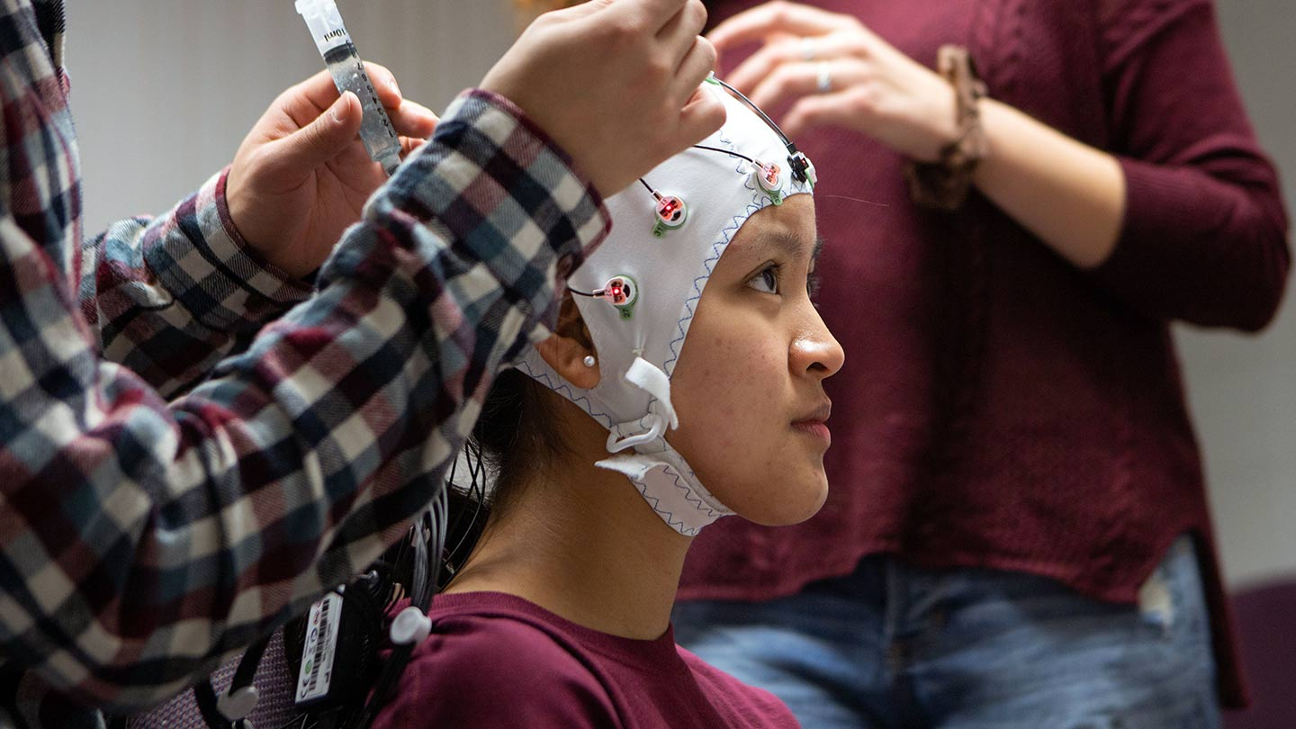 A student with medical sensors on their head
