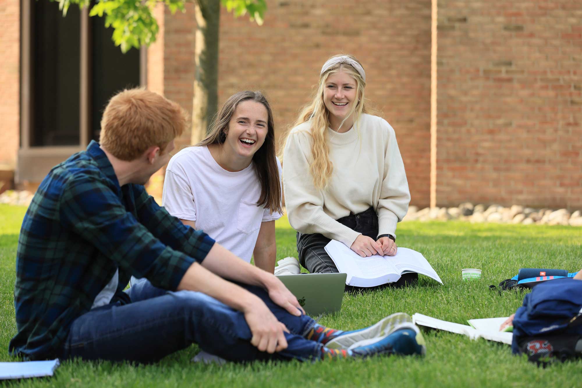 Calvin student study on commons lawn.