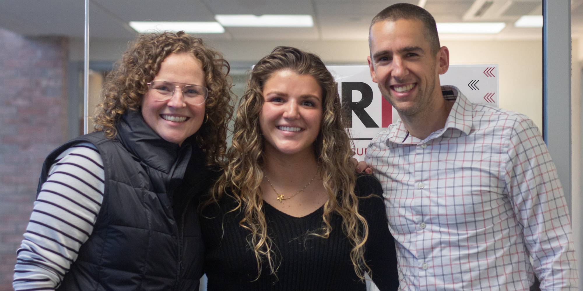 Calvin student Emma Fankhauser standing with two Calvin staff members.