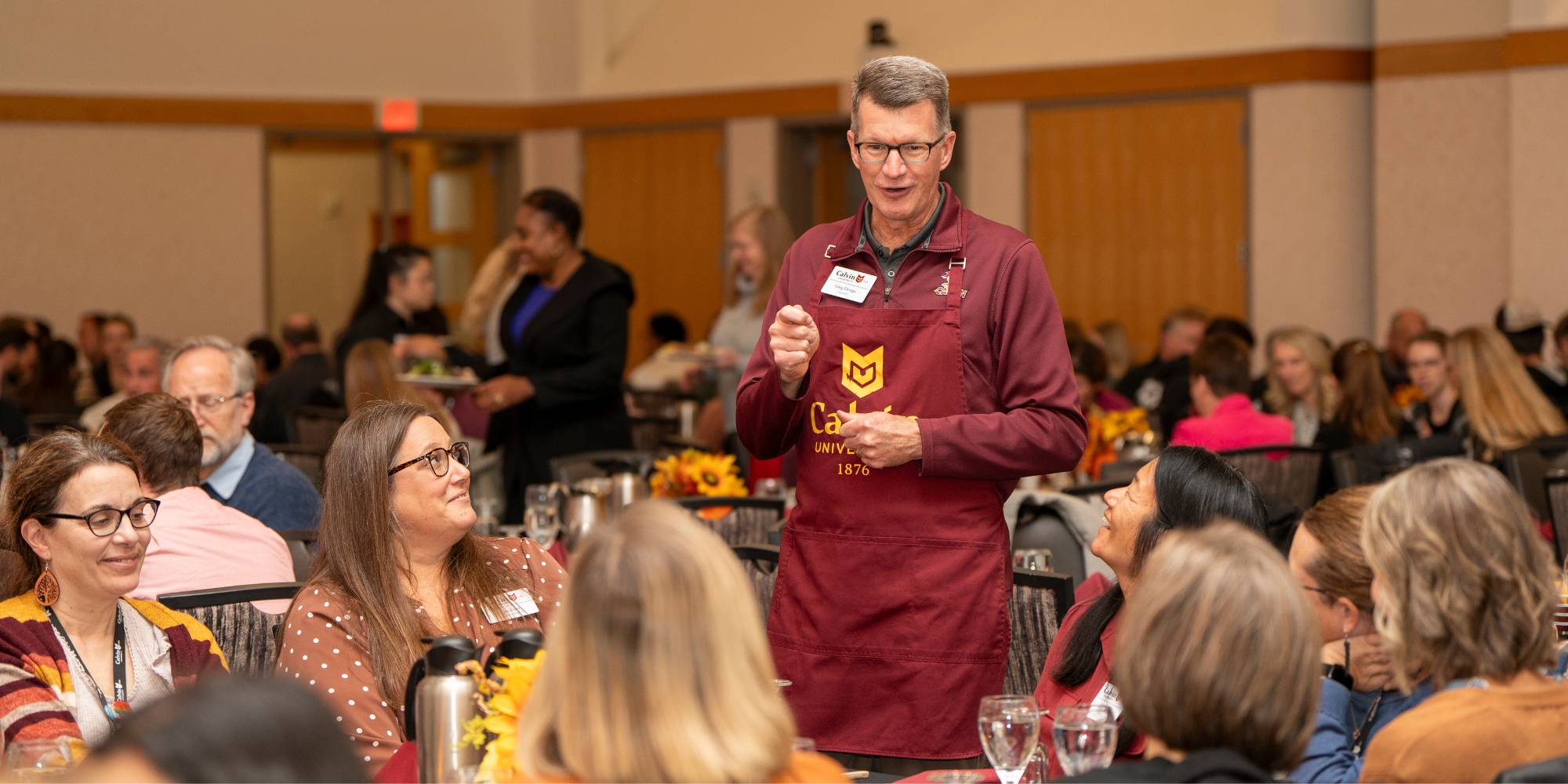 President Greg Elzinga visits with faculty and staff during a Thanksgiving lunch on Calvin's campus.