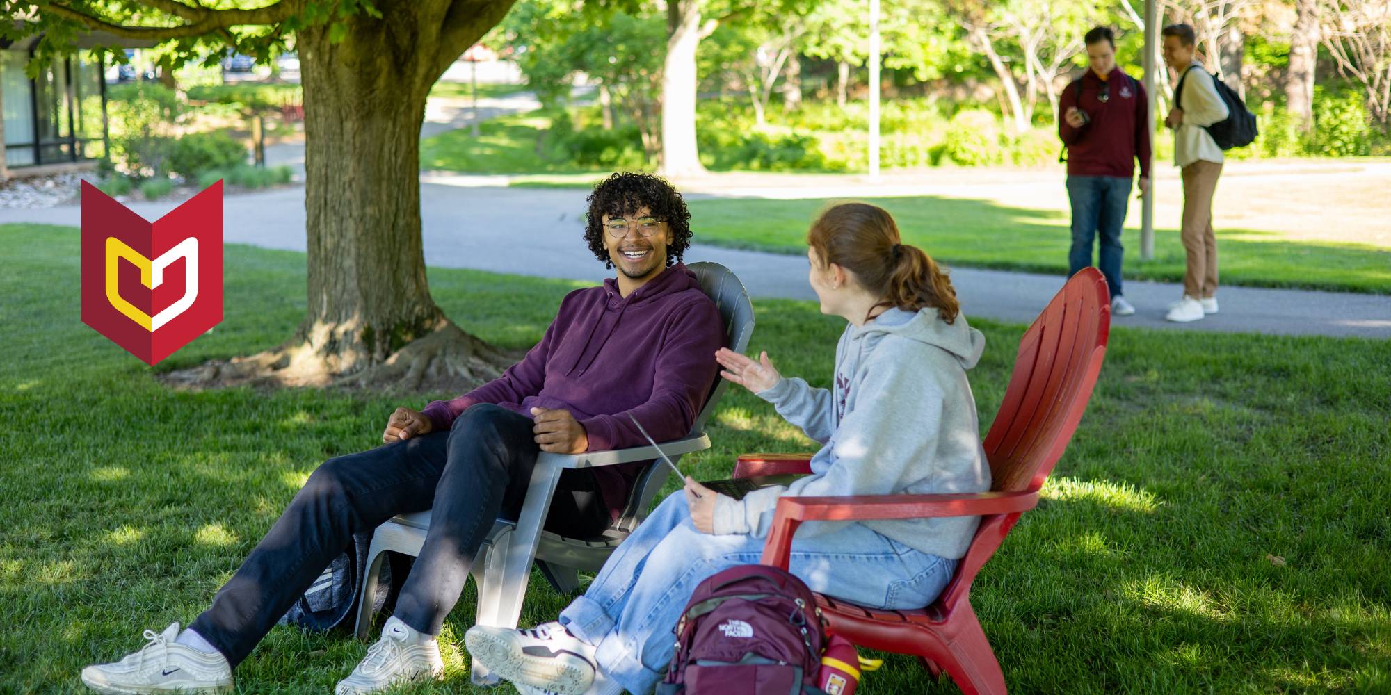 Students sitting on Calvin University's Commons Lawn talking 