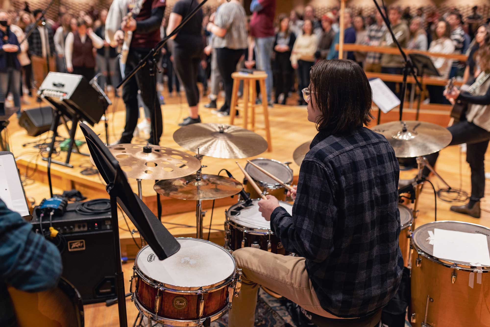 A drummer plays behind the student worship team during Calvin chapel.