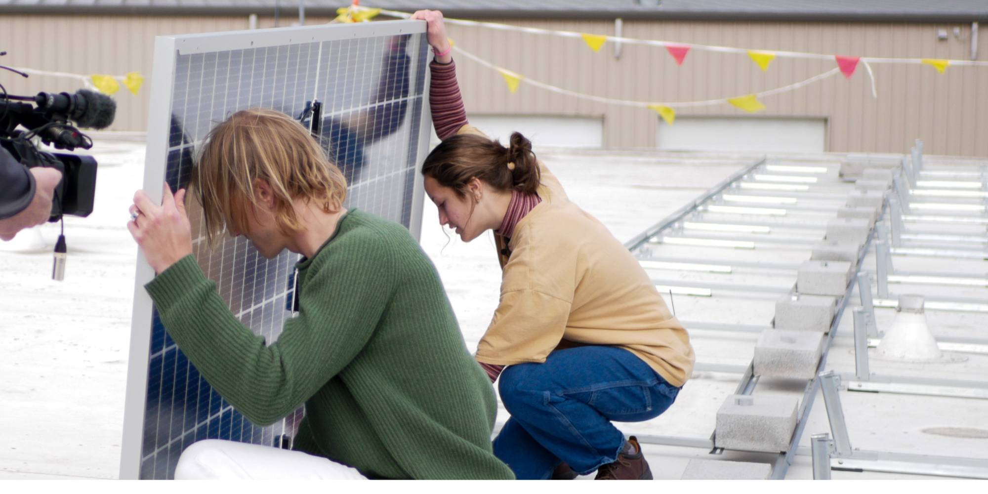 Jack Klop and Sofie Schumerth install solar panels at Calvin University