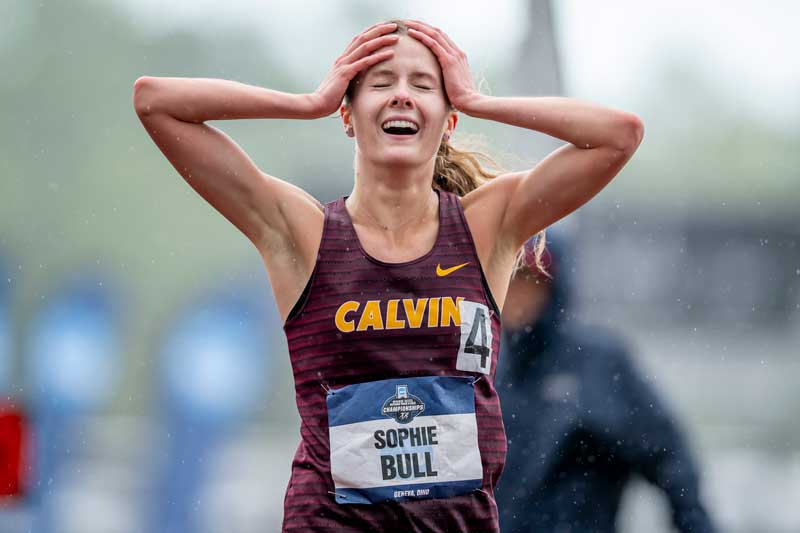 Sophie Bull reacts to winning the national championship steeplechase, gripping her head in her hands and smiling in celebration.