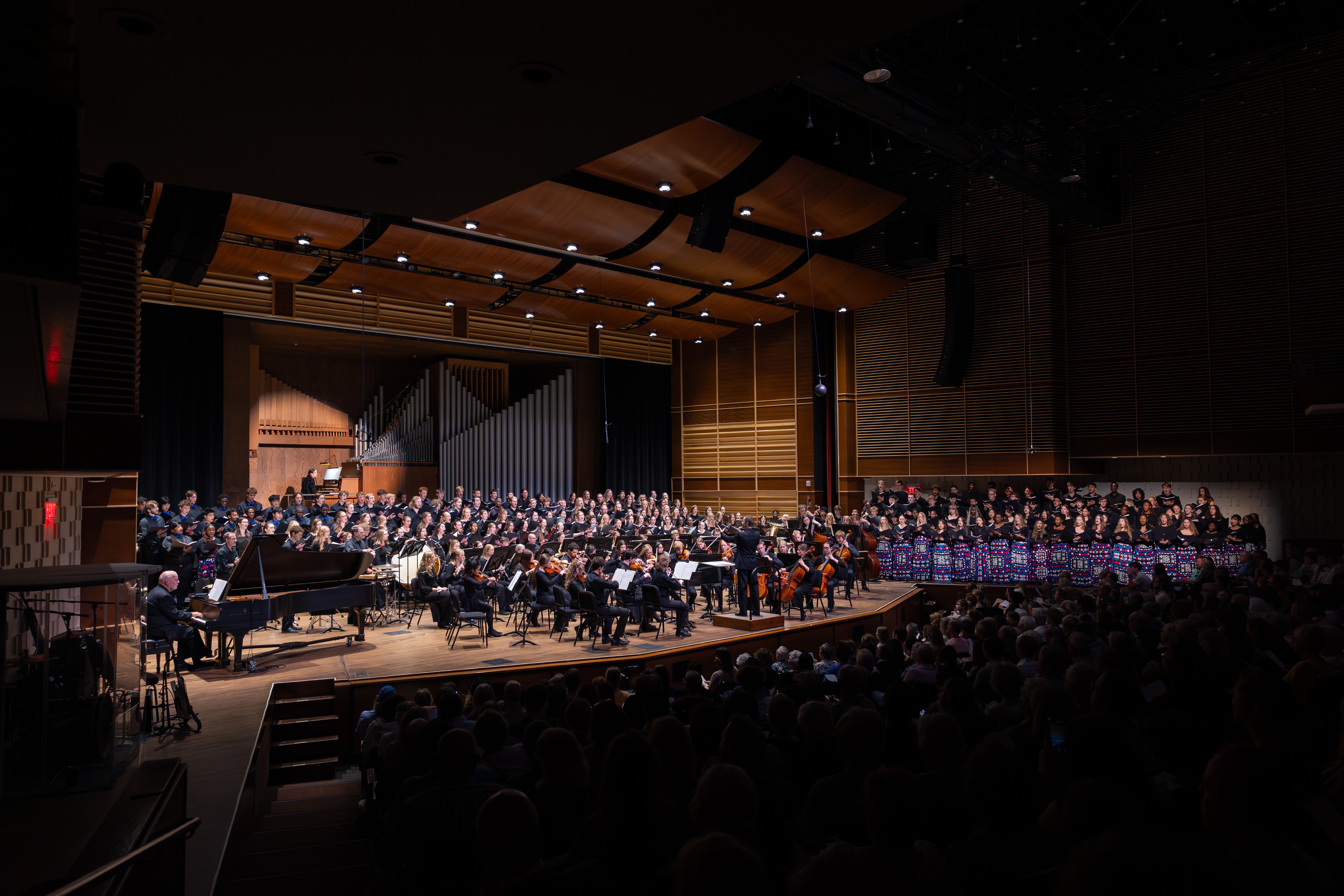 Choir on risers with orchestra in front.