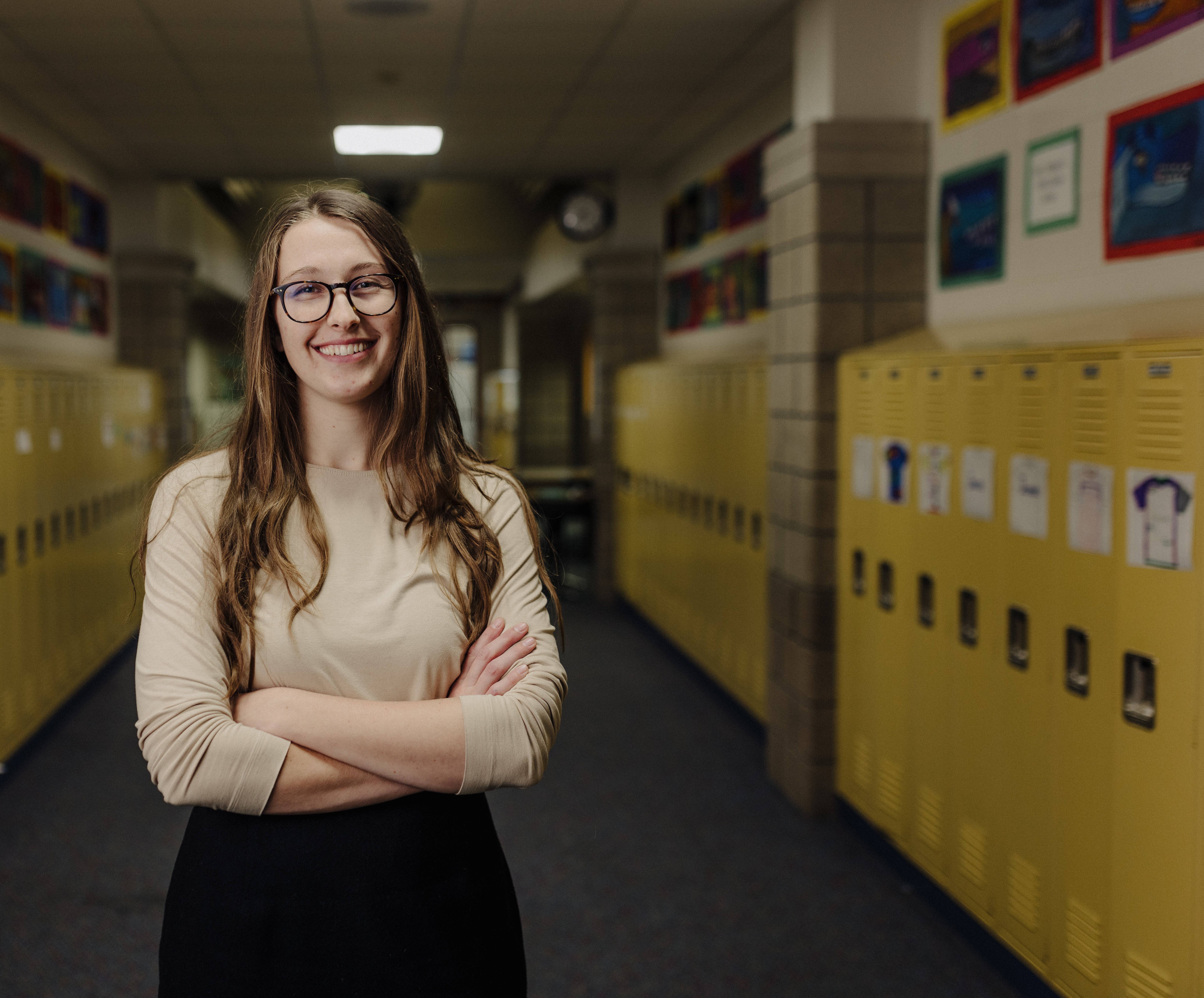 Calvin education student in a hallway with lockers