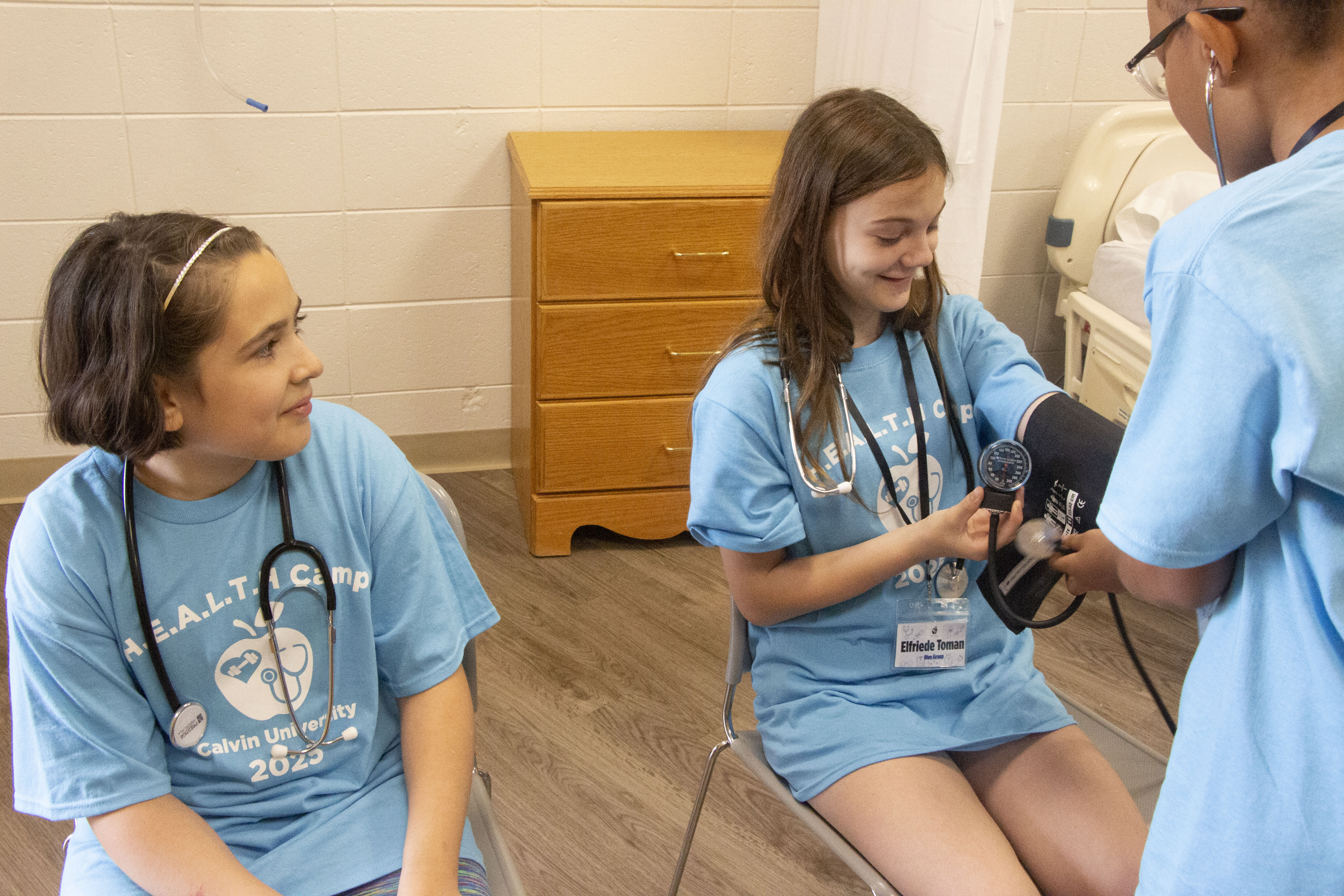 Young girls tacking each other's blood pressure