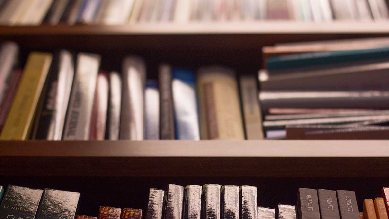 A close-up view of bookshelves with stacks of academic books.