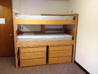 A bunk bed arrangements with two dressers beneath, supported by leg extensions.