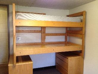 A bunk arrangement stacked on top of dressers, with beds supported on legs.
