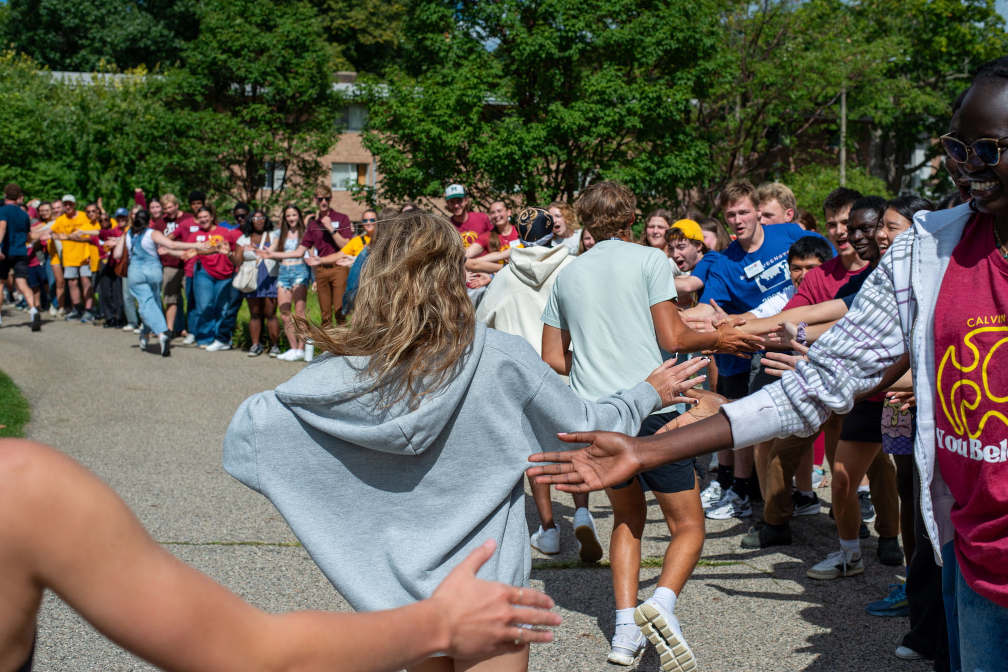 Lots of students line the path on Calvin's campus, giving high fives to new students on move-in day.