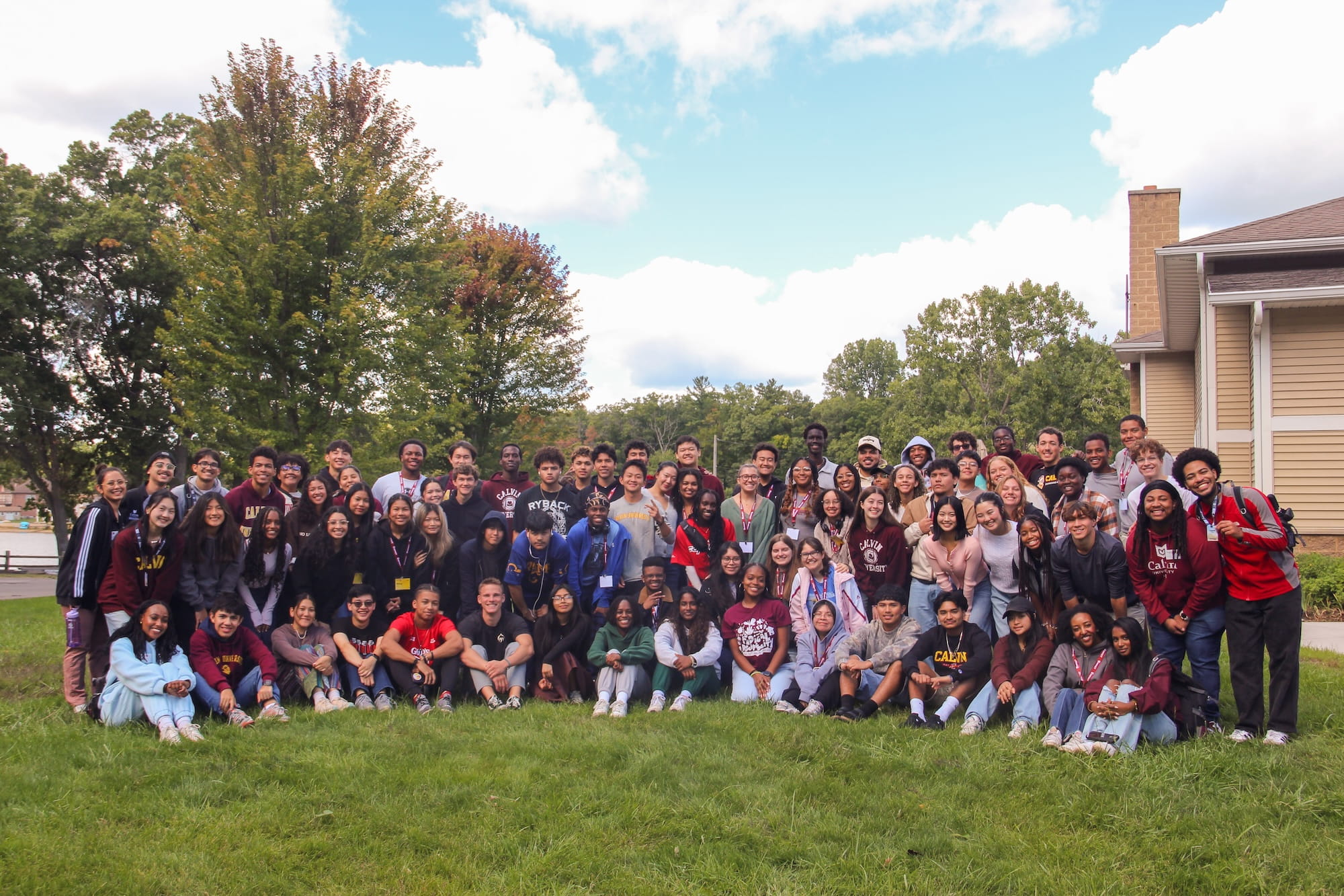 A large and diverse group of students poses on the Commons lawn at Calvin University.